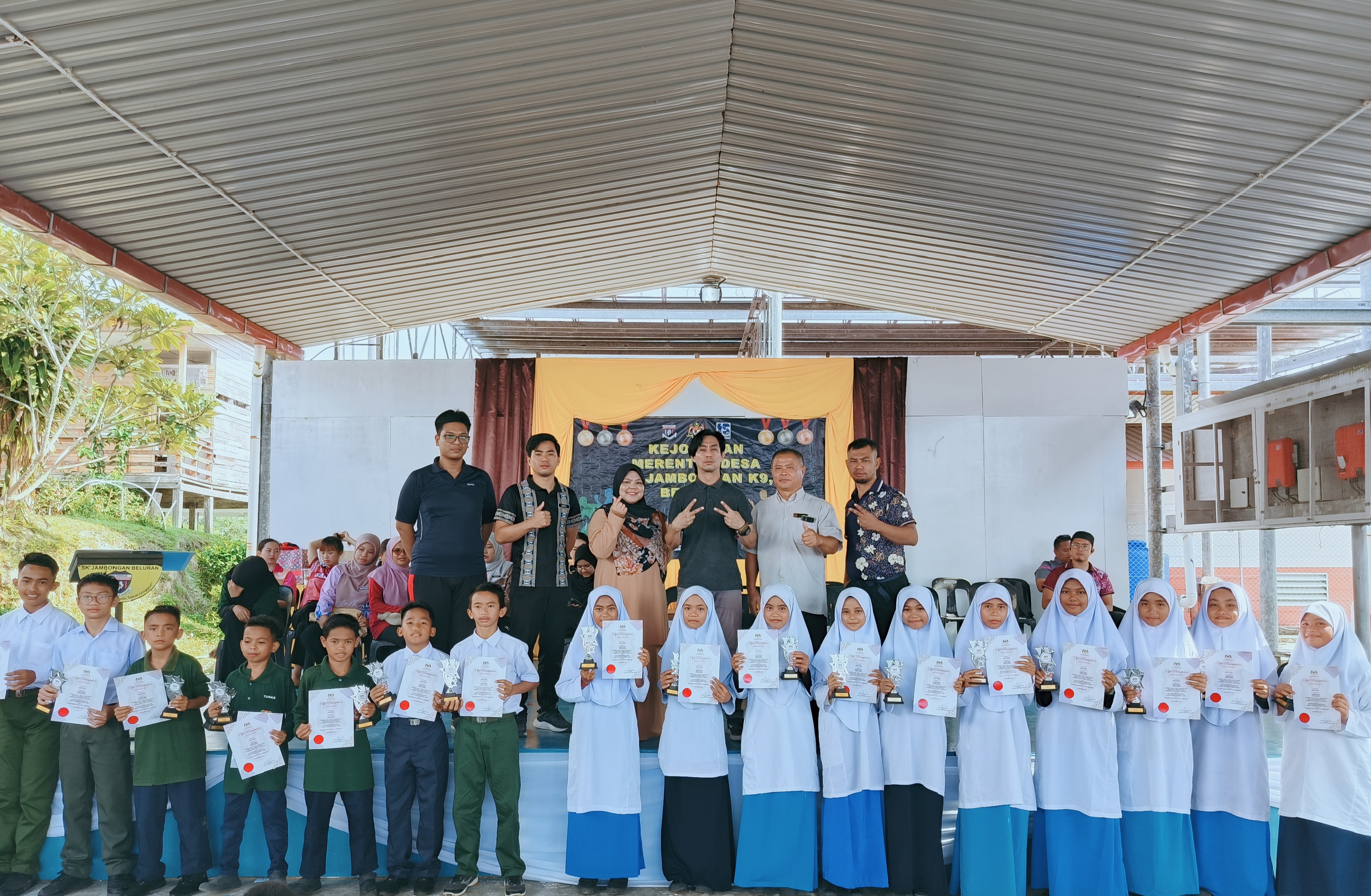 Murid menerima sijil dan piala kecemerlangan